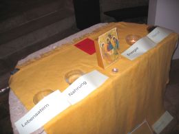 Am Altar die Dreifaltigkeits-Kiste und in den Glasschalten die Elemente Erde-Feuer-Wasser-Luft, Sinnbild für Natur-Energie-Nahrung-Lebensatem @ Kunst im Karner - St. Othmar